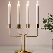 Gold candelabra with four white candles on a neutral background