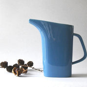 Blue ceramic pitcher on a white background .