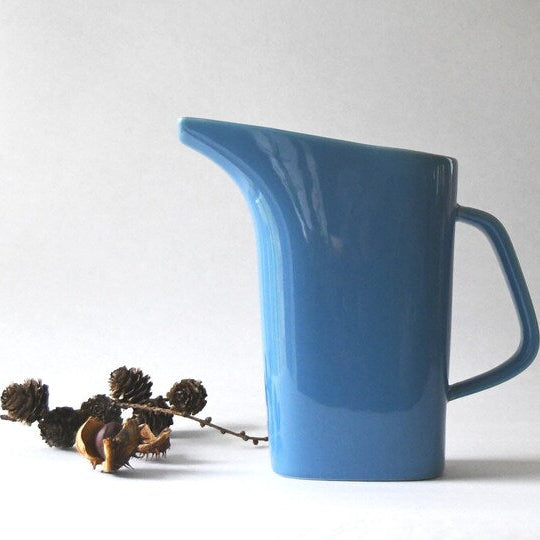 Blue ceramic pitcher on a white background .